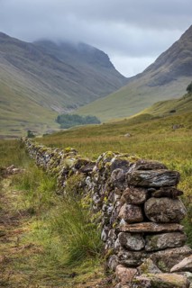 Old dry stone wall in moorland leading to the mountain Bidean nam Bian and the famous Three Sisters of Glen Coe