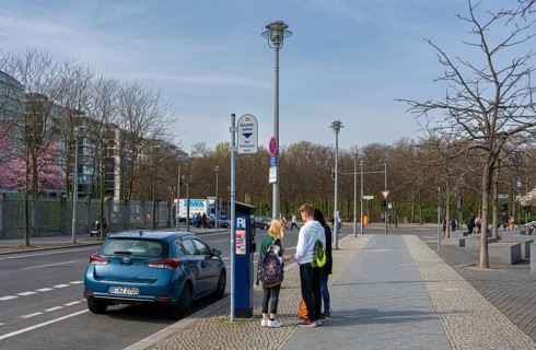 Young people standing next to a parking machine