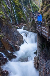 Tourist looking at the waterfall in the Wimbachklamm gorge in Ramsau bei Berchtesgaden
