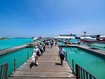 Tourists board pontoon with seaplanes