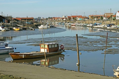View of coastal creek with boats at low tide