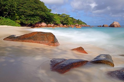 Beach and rocks of Anse Lazio in the evening
