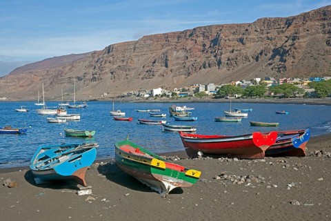 Colourful wooden fishing boats on the black sand beach of Tarrafal de Sao Nicolau on the island of Sao Nicolau