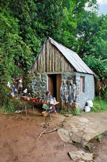 Woman sitting in front of stone house