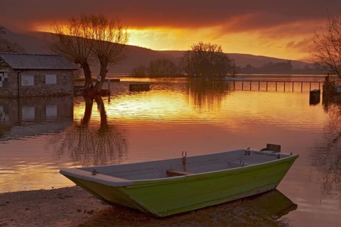 Boat on the lake at sunrise at high water level