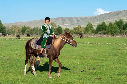 Kazakh boy in traditional dress on a horse