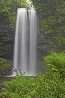Waterfall flowing over a defaced sandstone rim