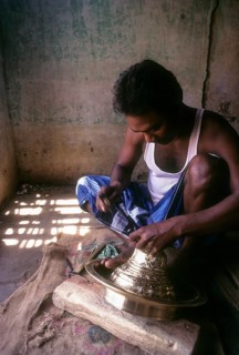 An artisan working on brass lamp at Nachiyar Koil near Thanjavur