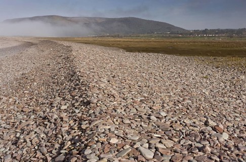View of shingle bank spreading inland as sea levels rise