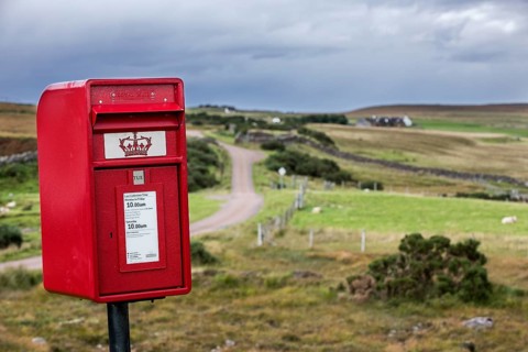 Traditional red Royal Mail letterbox in the bleak landscape at Coigach