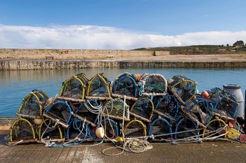 Pile of lobster pots stacked on quayside