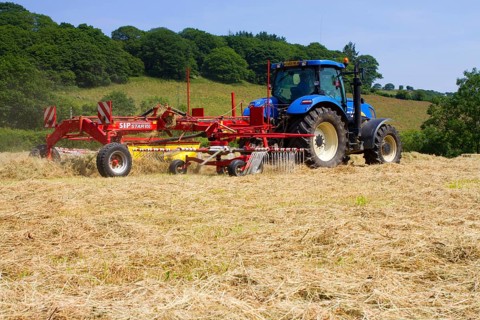 Contractor with New Holland T7030 tractor and SIP hay tedder