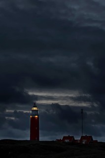 Eierland lighthouse with lantern light over the Wadden Sea at night on the Dutch island of Texel