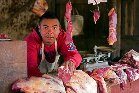 Malagasy butcher selling meat in an open-air butchery in the streets of Ambalavao town