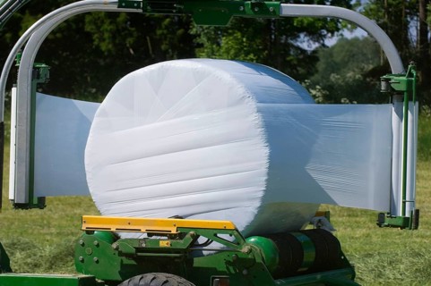 Plastic wrapping round silage bales with mechanical bale wrapper