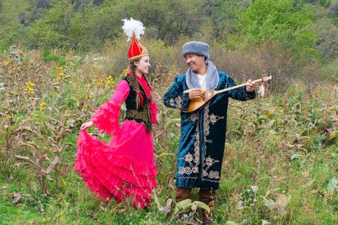 Kazakh man singing and playing dombra for a woman