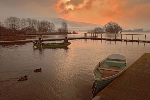 Anglers in a boat at dawn on the lake