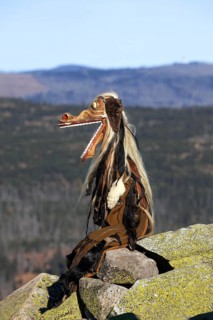 Creepy wooden devil figure on the summit of the Lusen in autumn