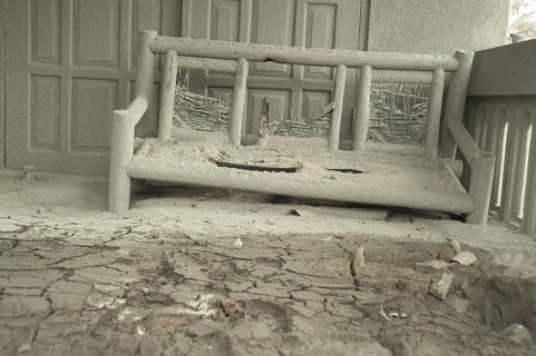 Ash-covered seat outside the house damaged by the recent volcanic eruption