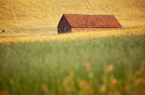 Red stone built barn in a hay meadow