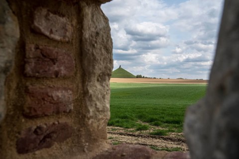 View over the Waterloo battlefield and Lion's Hill through a loophole in the garden wall of the Chateau d'Hougoumont