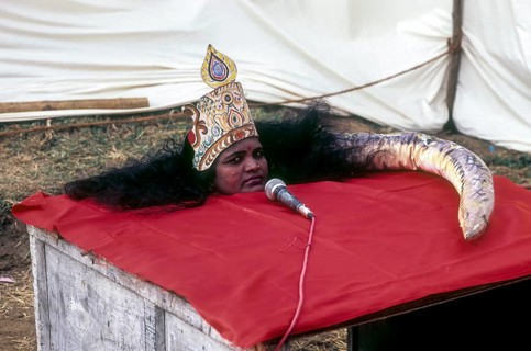 A woman performing a magic show like snake in a village exhibition