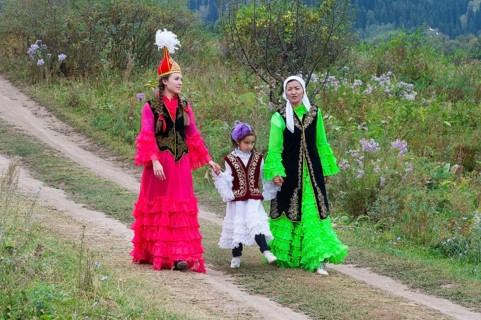 Two Kazakh woman walking with a child