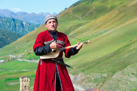 Georgian musician of a folklore group playing panduri