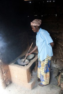 Woman preparing food at the cooker in a hut