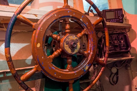 Wooden steering wheel on the bridge of a fishing boat at the Port Musee