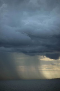 Rainstorm approaching over sea at dusk