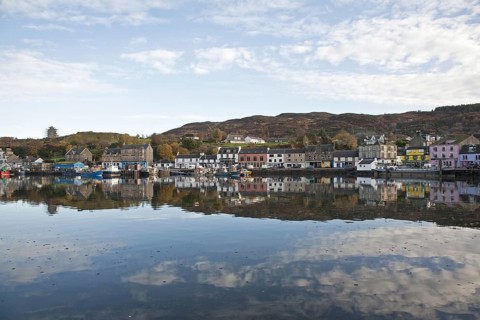 View of boats moored at town harbour in sea loch