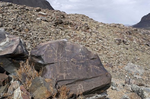Ancient petroglyphs depicting animals and people hunting