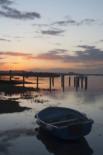 View of boats in coastal stream at high tide
