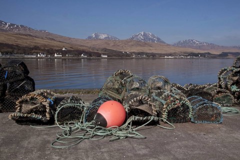 Lobster pots and floats on the pier at Craighouse with the porridge from the Jurassic behind them