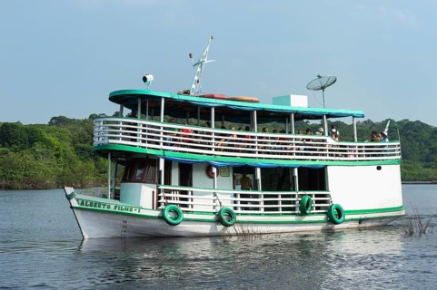 Traditional wood boat navigating with tourists on the Rio Negro