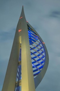 Spinnaker Tower illuminated under stormclouds at dusk