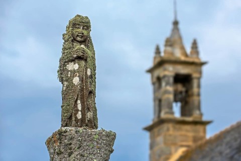 Weathered lichen-covered religious statue in the Chapelle Saint-They at the Pointe du Van