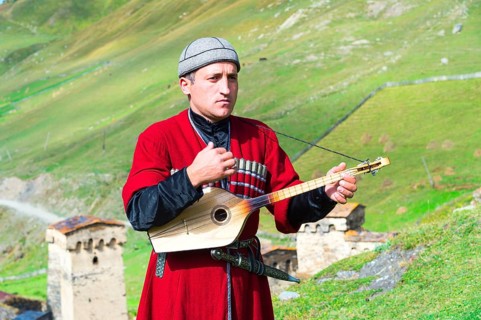 Georgian musician of a folklore group playing panduri