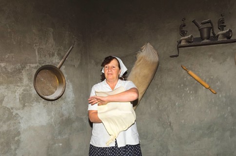 Armenian woman preparing Armenian lavash bread in the traditional tandoor oven