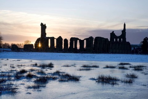 Ruins of the abbey silhouetted at sunset