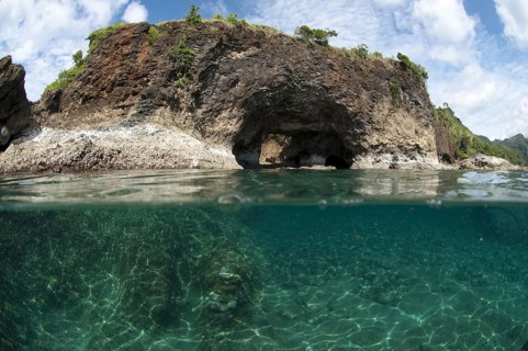 View of sea arch from above and below water