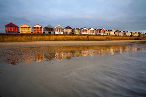 Beach huts on the seaside resort dyke at sunrise