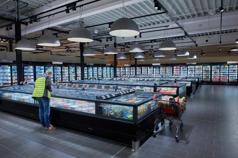 A man stands at a refrigerated display case