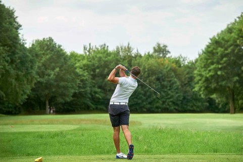 Golfer teeing off a ball