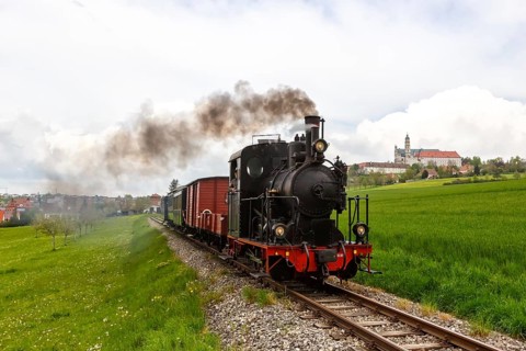 Steam train of the Haertsfeld Museumsbahn Schaettere railway steam train with Neresheim monastery