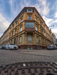 View of historic corner building in the city centre with manhole cover lid in the foreground