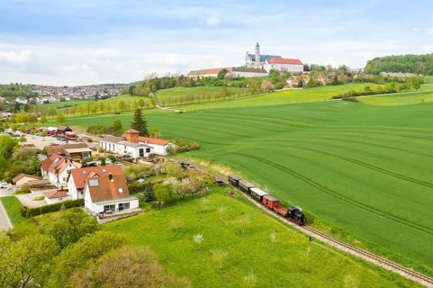 Steam train of the Haertsfeld Museumsbahn Schaettere aerial view railway steam train with Neresheim monastery
