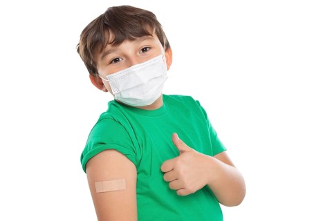 Child boy with plaster at children vaccination mask showing thumbs up against corona virus corona virus isolated exempt in Stuttgart