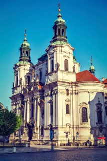 Vintage retro hipster style travel image of St. Nicholas church at Old Town Square early in morning
